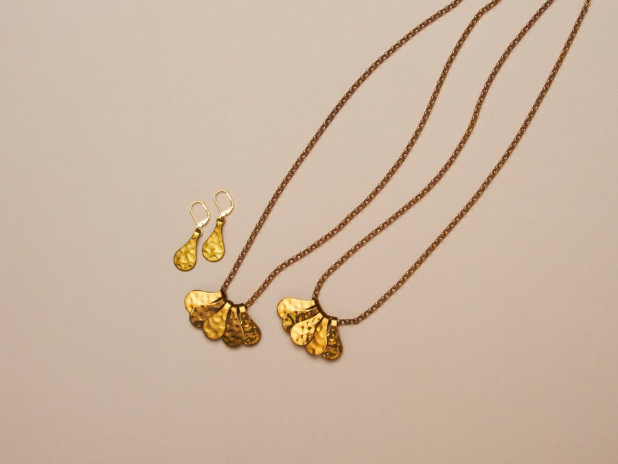 Fragment Necklace with five pieces that work together to form a pendant. The pieces slide freely along a brass chain. Shown with Fragment Earrings.