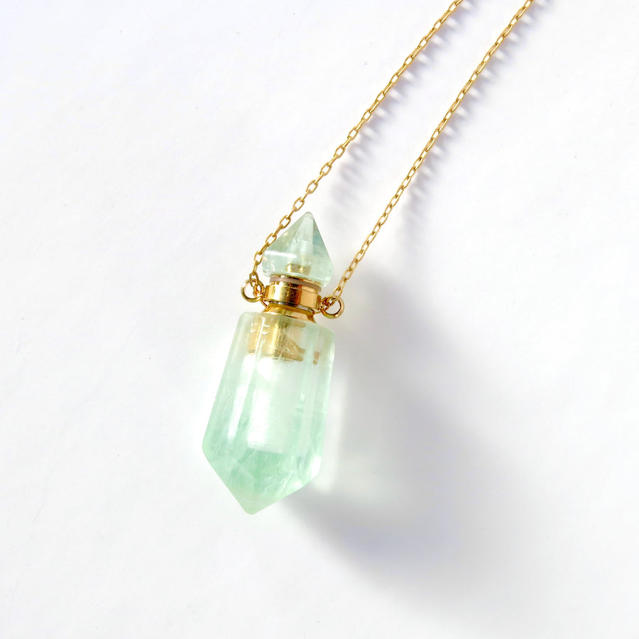 Aroma Necklace features pendant that is a small functioning bottle made of semi-precious stone floating on fine brass chain. Shown in aventurine.
