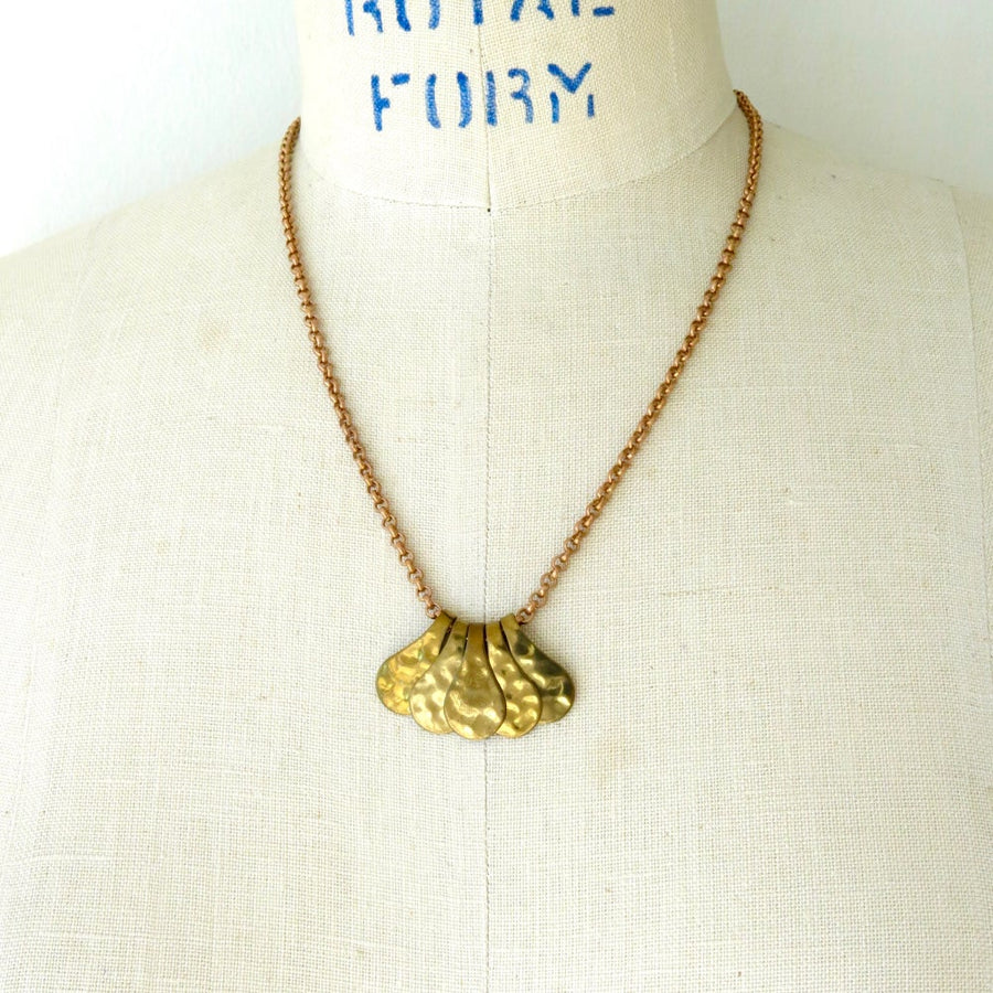 Fragment Necklace with five pieces that work together to form a pendant. The pieces slide freely along a brass chain.