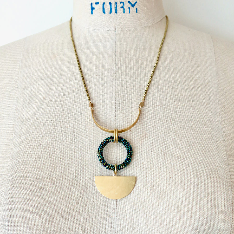 MoonRox Halo Necklace features a pendant with hand beaded circular form. Shown in Oil Slick colour.
