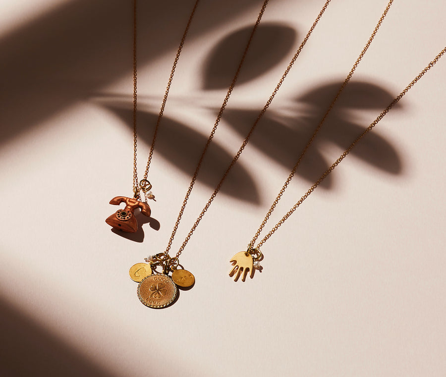 Share a greeting with the Hello, Token or Hi Five Necklaces made with brass charms and freshwater pearl. 