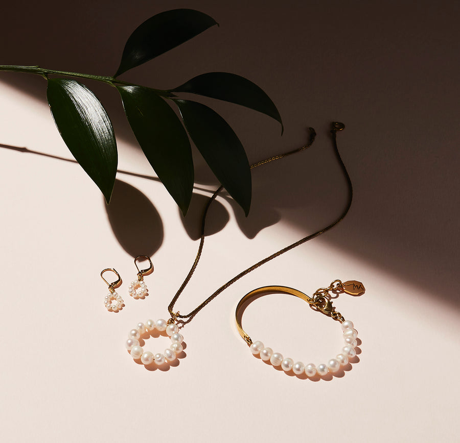 The Illuminated Necklace is a simple and elegant yet modern take on pearls. A pendant of hand wired freshwater pearls in a circular form. Shown with matching Illuminated Bracelet and Earrings.  