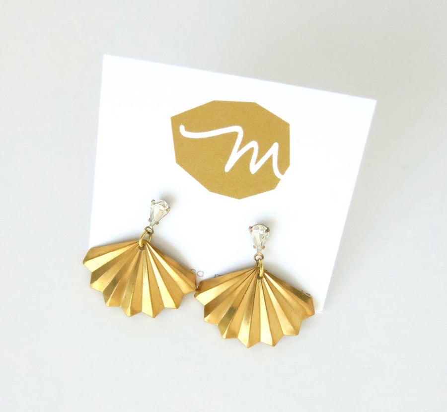 Fan shaped brass charm with pleated pattern is hung below rhinestone crystal stud earrings.