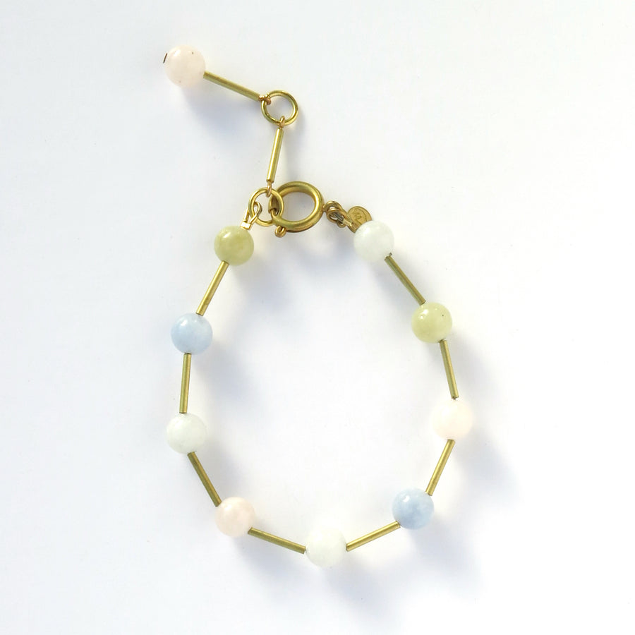 Resilience Bracelet made of round semi-precious stones staggered with brass tubes. Shown in multicolour morganite.