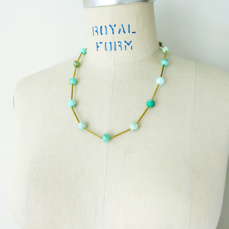 Resilience Necklace by MoonRox can be worn as a lariat or a necklace. Semi-precious stones are spaced along brass components. This photo shows the necklace in chrysoprase.