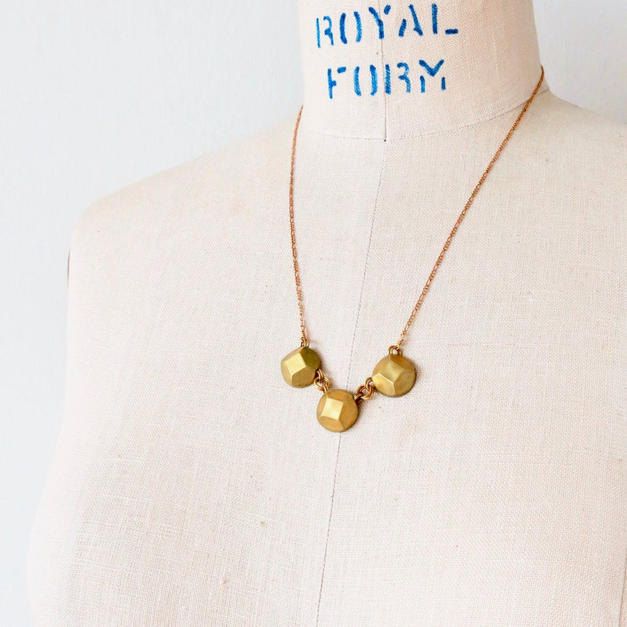 Reverie Trio Necklace by MoonRox features a trio of faceted brass jewels connected to a lovely brass chain