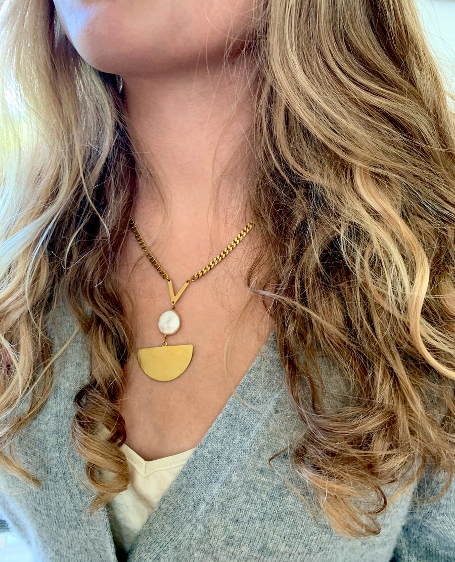 Sail Away With Me Necklace is a chain necklace with pretty coin shaped freshwater pearl sitting atop a large semi-circular brass pendant.
