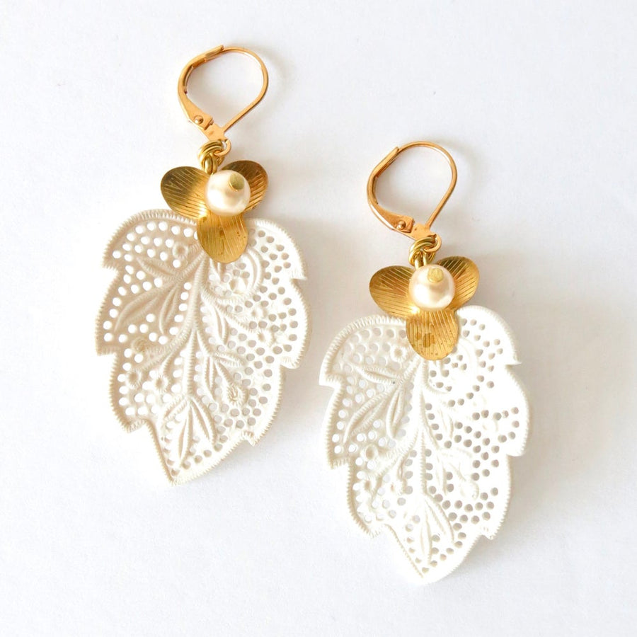 Secret Garden Earrings by MoonRox Jewellery & Accessories showcase white vintage celluloid lace leaves accented with brass flowers and glass pearls.