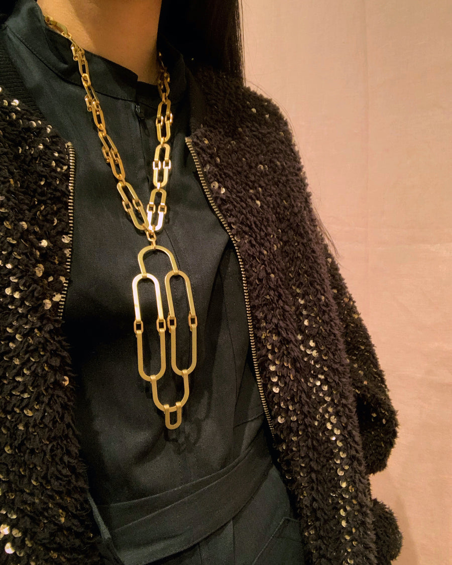 Splendour Necklace by MoonRox Jewellery & Accessories is made with curvilinear brass forms linked together in an art deco inspired statement piece.  Shown styled with black outfit.