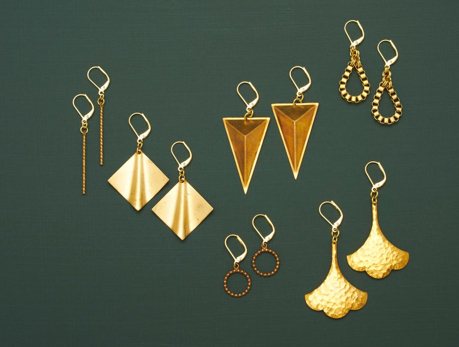 Twist Earrings are shown with the Undulate, Monument, Bound, Hammered Swish and Stippled Loop Earrings. Your choice of brass charm earrings.