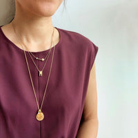 Token Necklace by MoonRox - Charm necklace with assorted coin shaped charms shown layered with Wisdom Pearl Necklace and Initial Impressions Necklace.